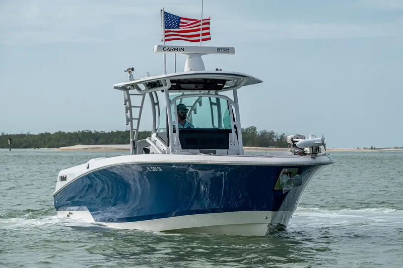 Slide: The Image of 2020 Wellcraft 302 Fisherman boat cruising on water with American flag. - 3