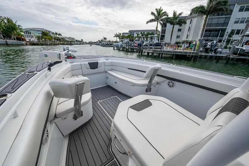 Slide: The Image of 2020 Wellcraft 302 Fisherman boat interior with white seating, dockside view, and palm trees. - 36