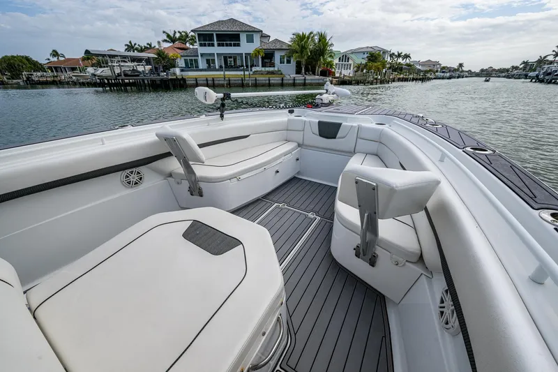 Slide: The Image of 2020 Wellcraft 302 Fisherman boat with spacious seating, docked near waterfront homes. - 37