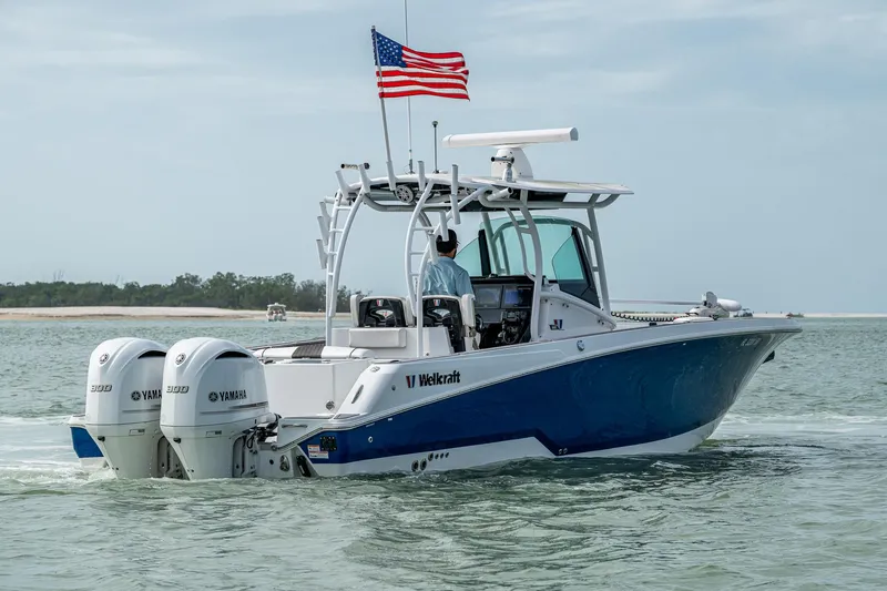 Slide: The Image of 2020 Wellcraft 302 Fisherman boat with dual Yamaha engines on the water, American flag flying. - 8