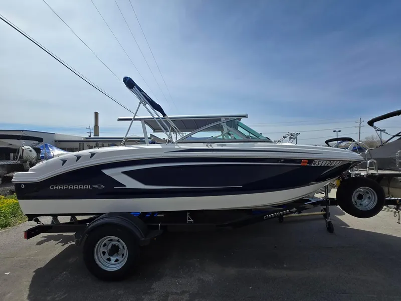 Slide: The Image of 2017 Chaparral 19H20 boat on trailer, side view, under clear blue sky. - 1
