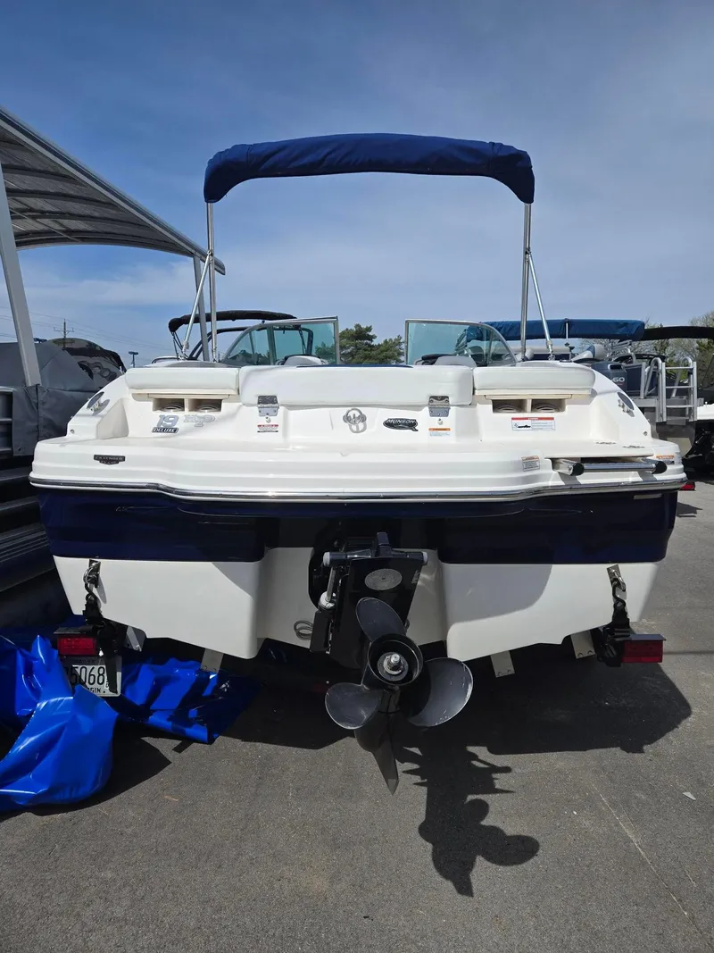 Slide: The Image of 2017 Chaparral 19H20 boat, rear view with propeller and blue canopy. - 12