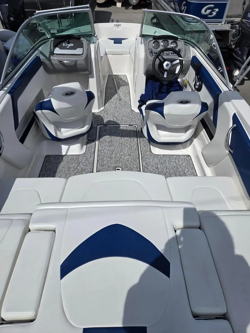 Slide: The Image of 2017 Chaparral 19H20 boat interior with white and blue seating and steering console. - 13