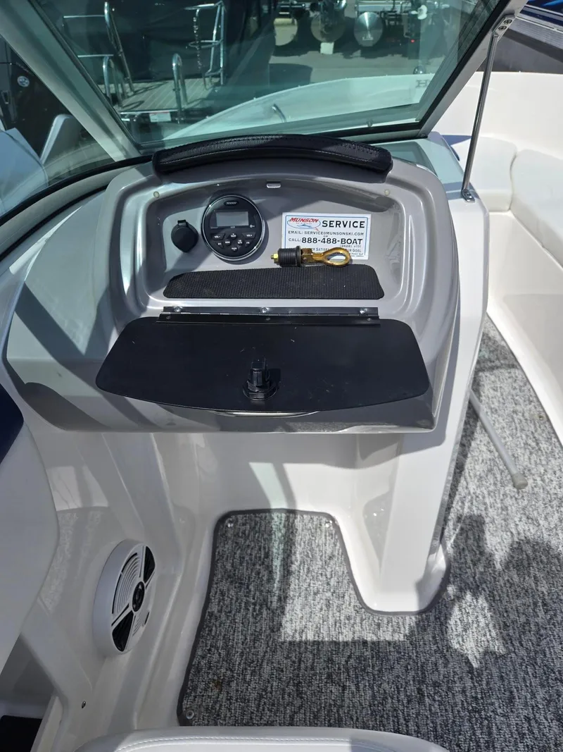 Slide: The Image of 2017 Chaparral 19H20 boat dashboard with control panel and service contact information. - 18