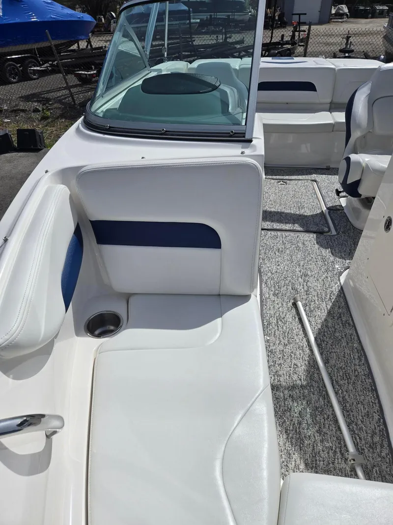 Slide: The Image of 2017 Chaparral 19H20 boat interior with white and blue seating, cup holder, and windshield. - 5