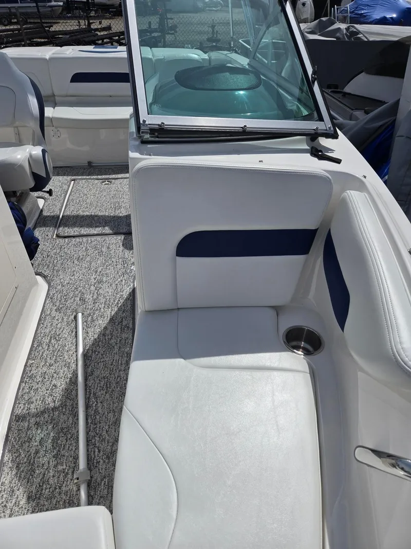 Slide: The Image of 2017 Chaparral 19H20 boat interior with white and blue seating, cup holder, and windshield. - 6