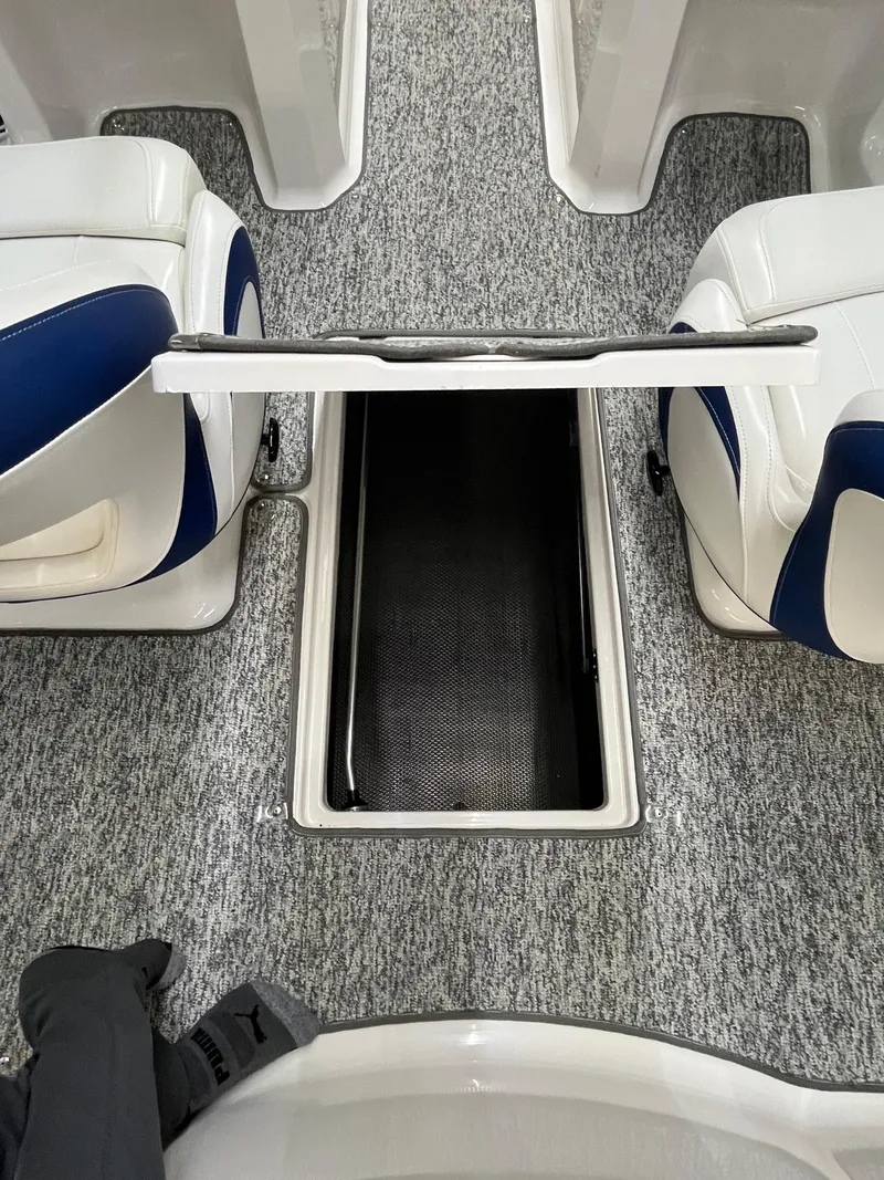 Slide: The Image of 2017 Chaparral 19H20 boat interior with open storage compartment between seats. - 9