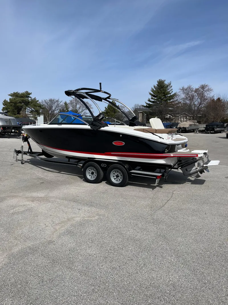 Slide: The Image of 2022 Cobalt CS23 boat on trailer, parked outdoors under clear sky. - 3