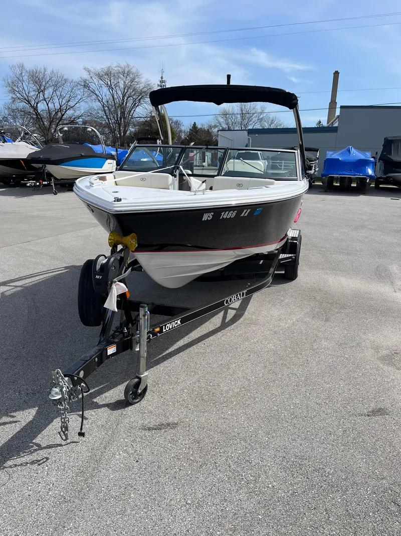 Slide: The Image of 2022 Cobalt CS23 boat on trailer in parking lot, clear sky background. - 4