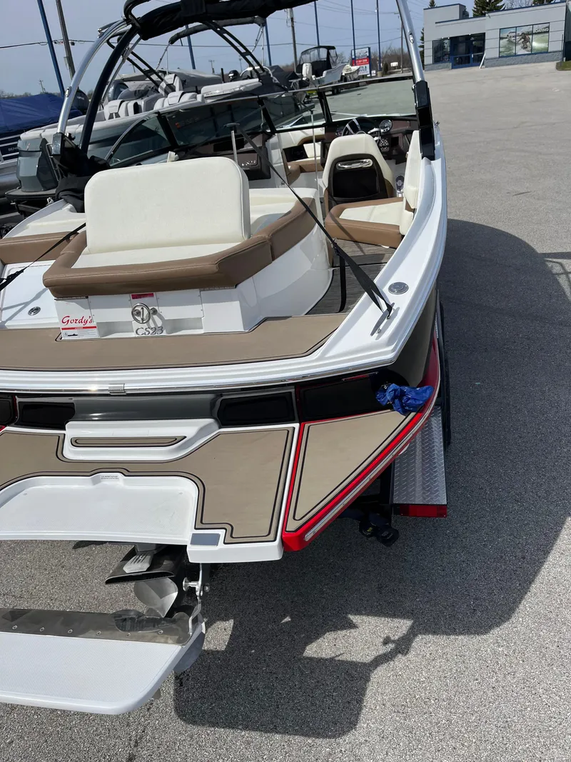 Slide: The Image of 2022 Cobalt CS23 boat with beige seating and sleek design, parked on a trailer. - 7