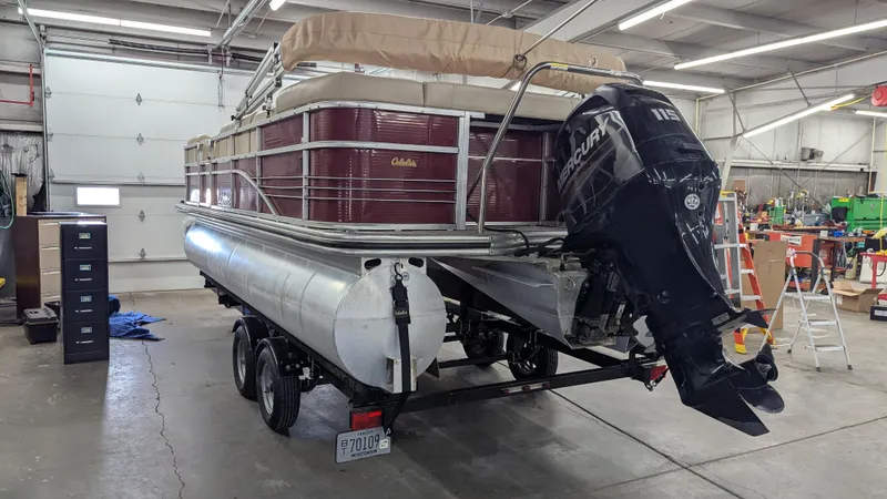 Slide: The Image of 2014 Lowe 2183 pontoon boat with Mercury 115 outboard motor in a garage. - 4