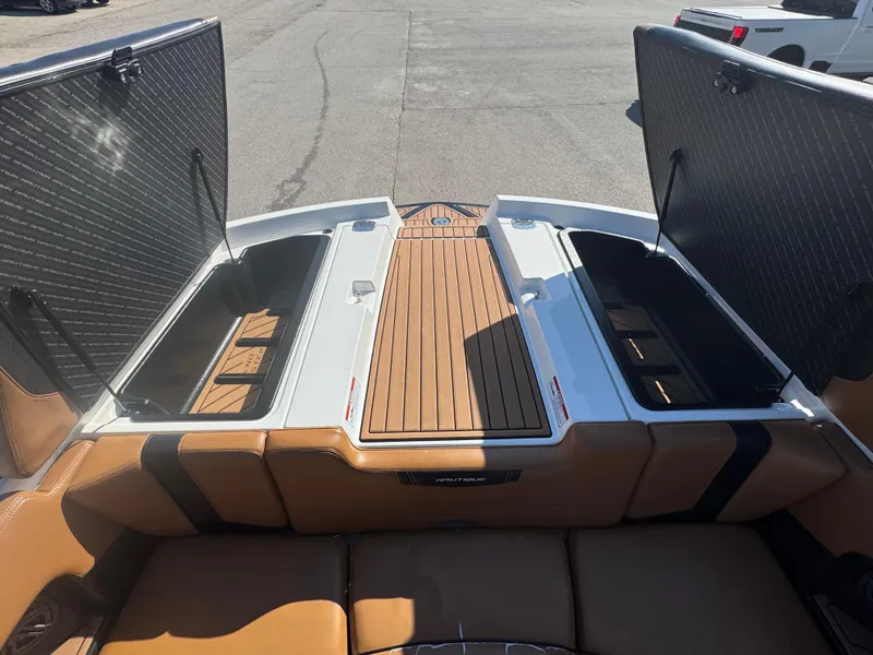 Slide: The Image of 2016 Nautique 210 boat with open storage compartments and teak deck. - 13