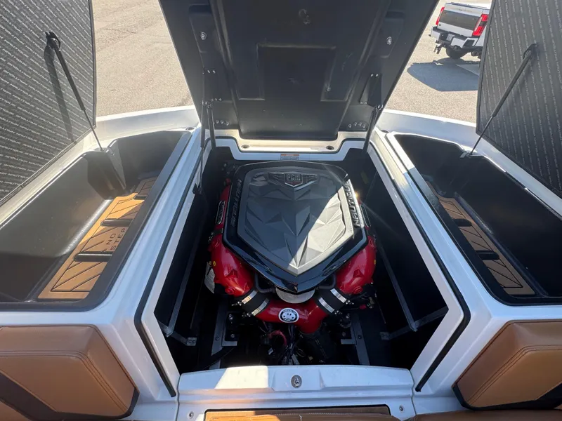 Slide: The Image of 2016 Nautique 210 boat engine compartment with open hatches, showcasing powerful engine. - 14