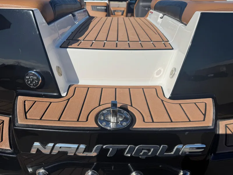 Slide: The Image of 2016 Nautique 210 boat with teak deck and sleek design details. - 18