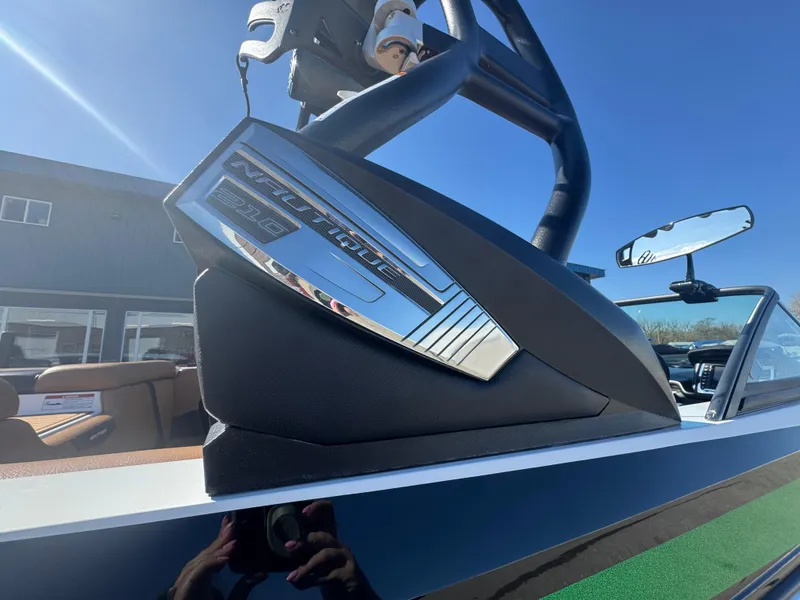 Slide: The Image of 2016 Nautique 210 boat with chrome detailing under clear blue sky. - 25