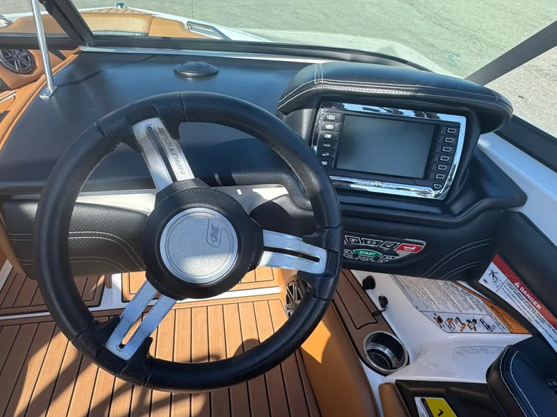 Slide: The Image of 2016 Nautique 210 boat dashboard with steering wheel and control panel. - 29