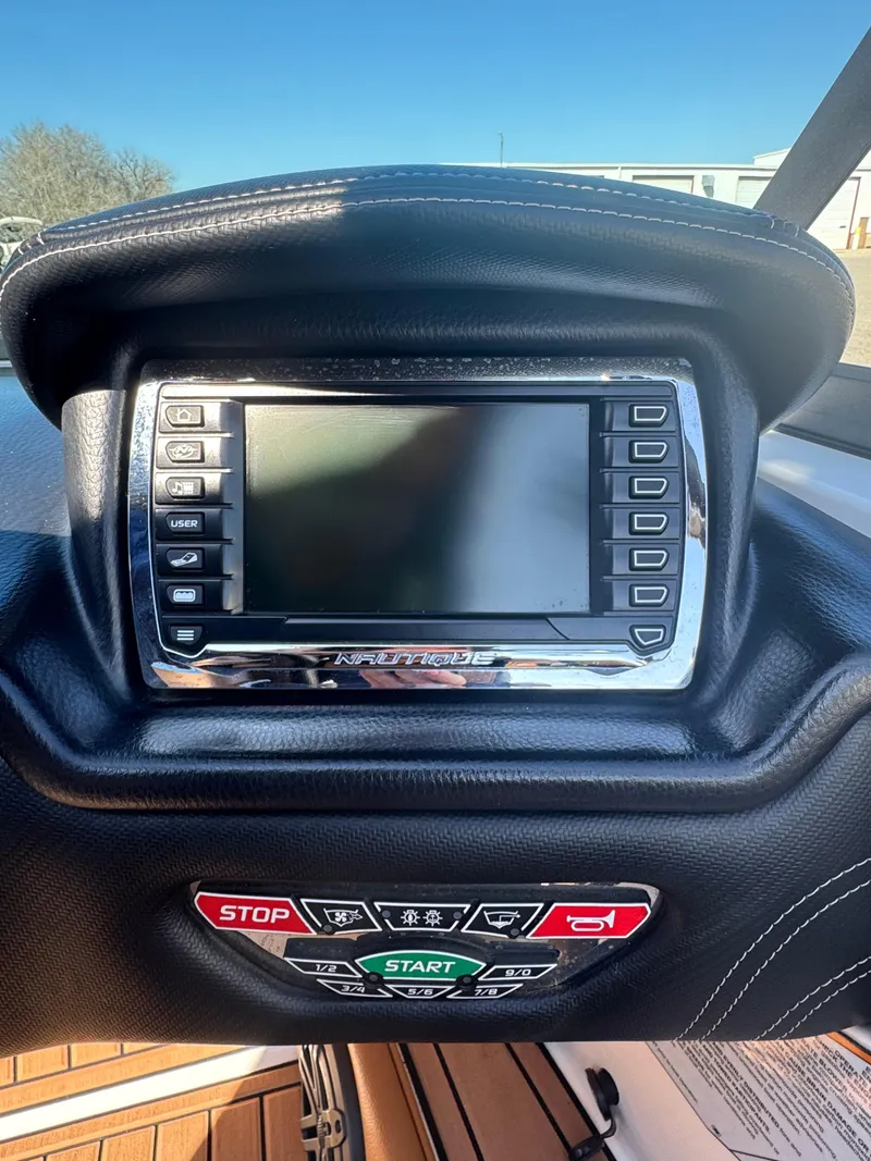 Slide: The Image of Dashboard of a 2016 Nautique 210 boat with control panel and display screen. - 31