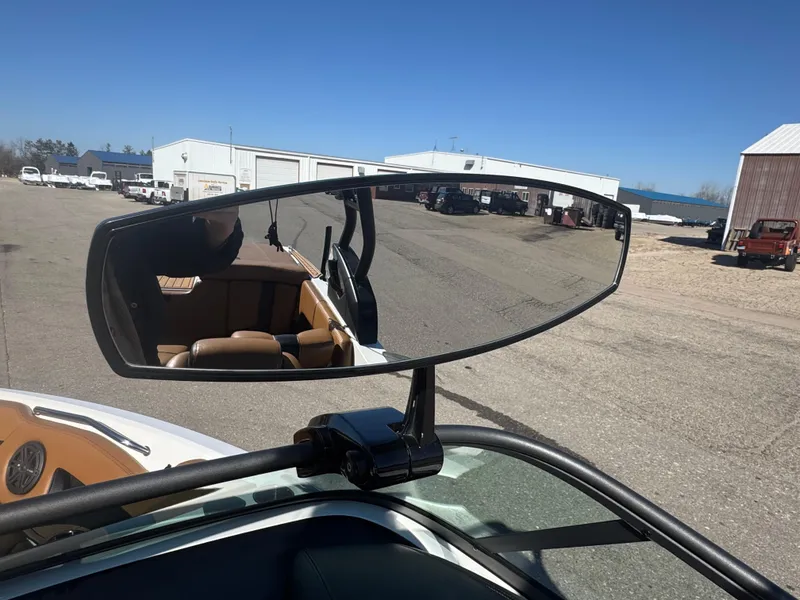 Slide: The Image of Rearview mirror of a 2016 Nautique 210 boat reflecting outdoor storage area. - 32