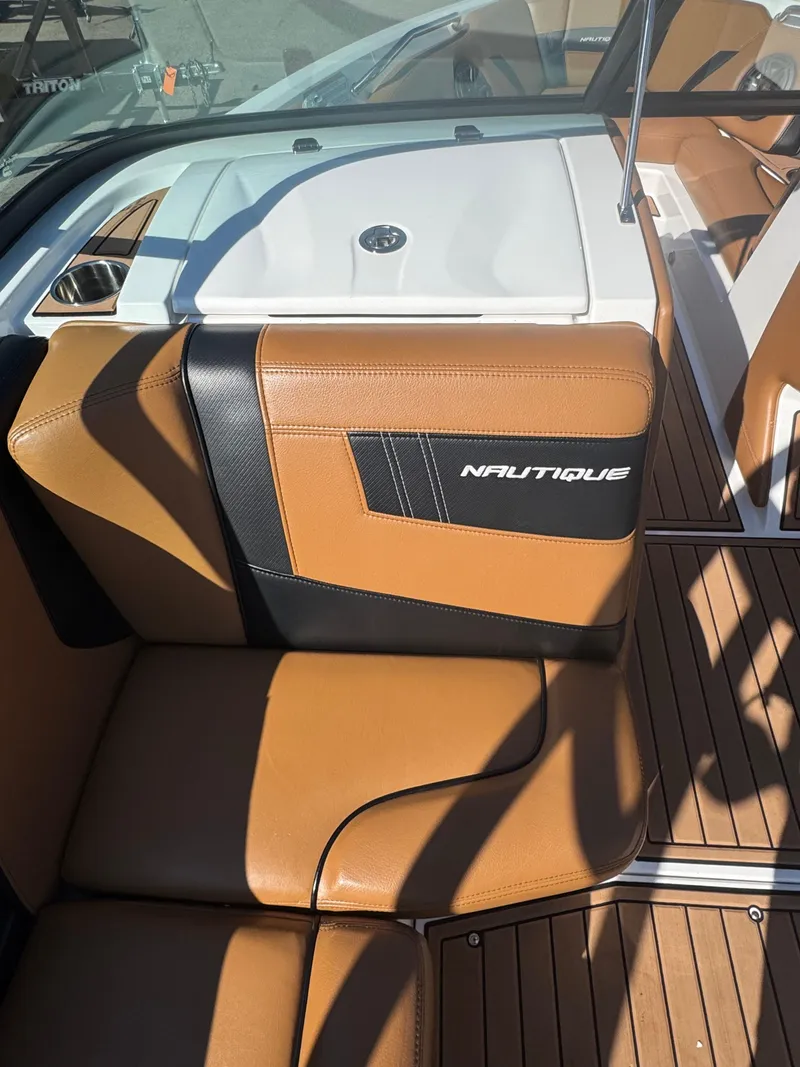 Slide: The Image of 2016 Nautique 210 boat interior with tan leather seats and sleek design. - 33