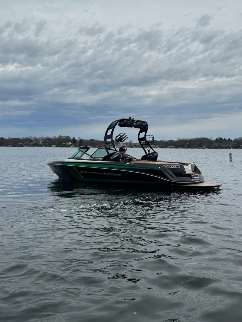 Slide: The Image of 2016 Nautique 210 boat on a calm lake under cloudy skies. - 4