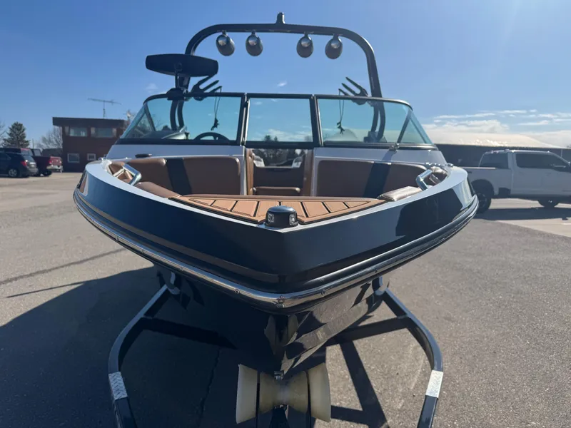 Slide: The Image of 2016 Nautique 210 boat on trailer, sunny day, parking lot background. - 7