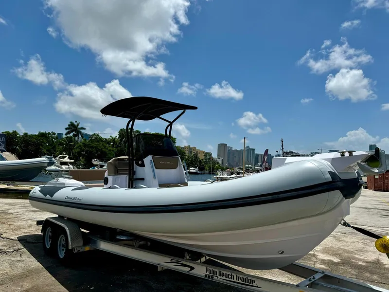 The Image of 2026 Ranieri CAYMAN 23 Sport boat on calm water, with lush greenery in the background. - 0