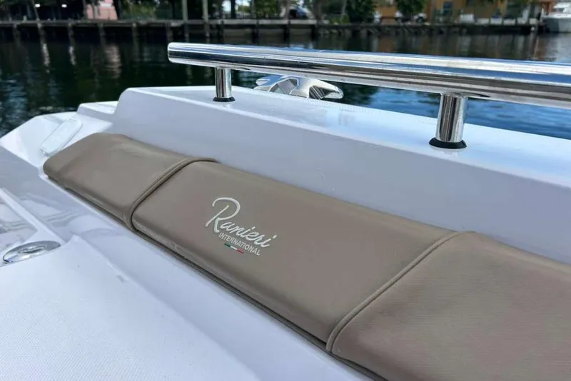 Slide: The Image of 2026 Ranieri CAYMAN 23 Sport boat with beige seating and chrome railing by the water. - 21