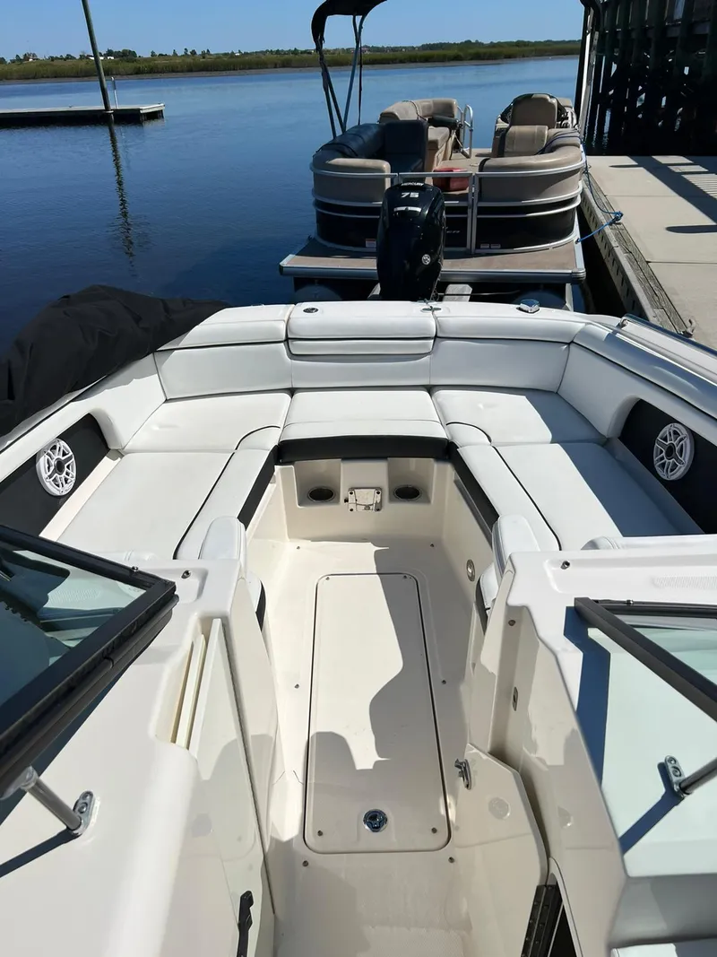 Slide: The Image of 2015 Sea Ray 290 Sundeck boat with spacious seating, docked by calm waters. - 11