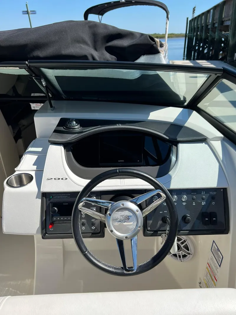 Slide: The Image of 2015 Sea Ray 290 Sundeck boat dashboard with steering wheel and controls. - 2