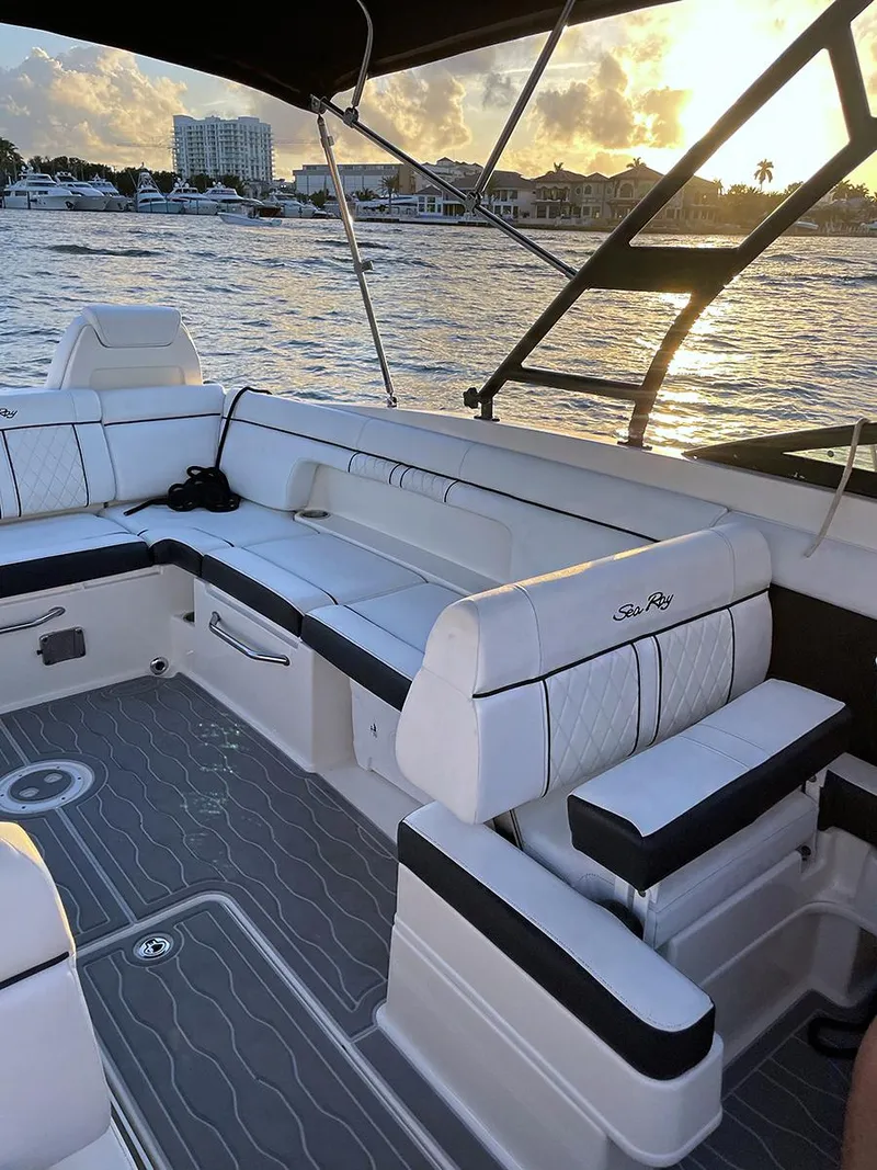 Slide: The Image of 2015 Sea Ray 290 Sundeck with white seating, docked at sunset. - 24