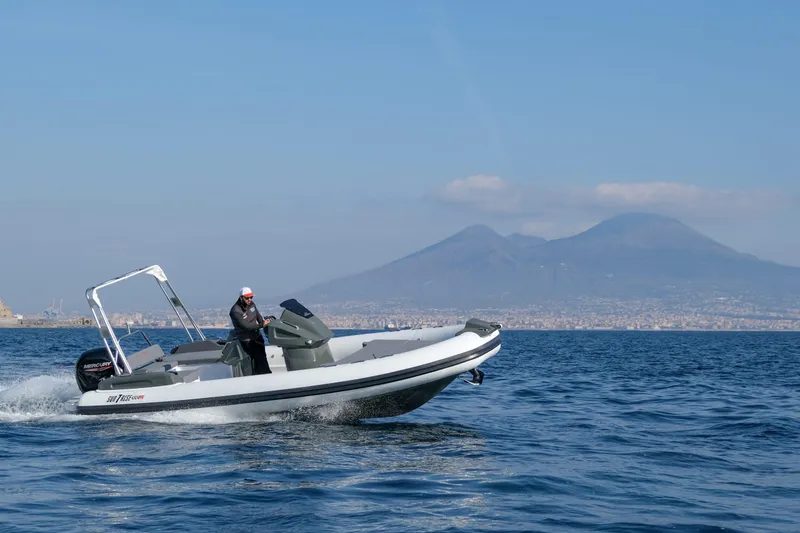 Slide: The Image of Custom Sunrise 24 boat cruising on blue waters with mountains in the background, 2024 model. - 4