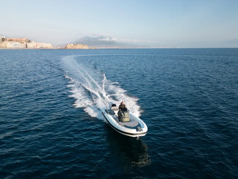 Slide: The Image of Custom Sunrise 24 boat cruising on open sea, 2024 model, with distant coastal view. - 6