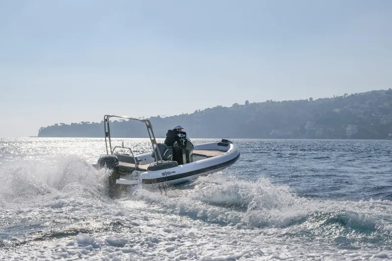 Slide: The Image of Custom Sunrise 24 boat navigating waves, 2024 model, with scenic coastal backdrop. - 7