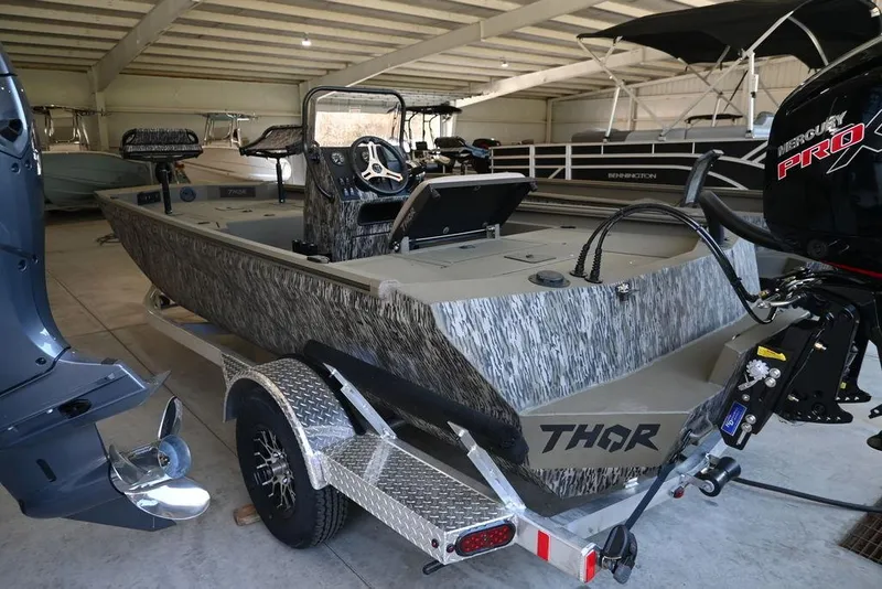 Slide: The Image of 2025 Thor Lake Hammer 1900CC boat in storage, featuring camouflage design and trailer. - 3