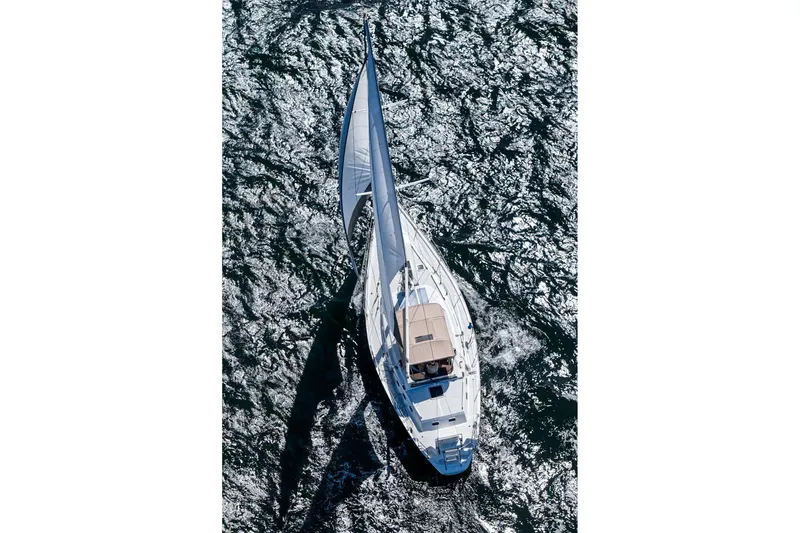 Slide: The Image of Aerial view of a 1992 Morgan 45 Catalina sailboat navigating through shimmering waters. - 27