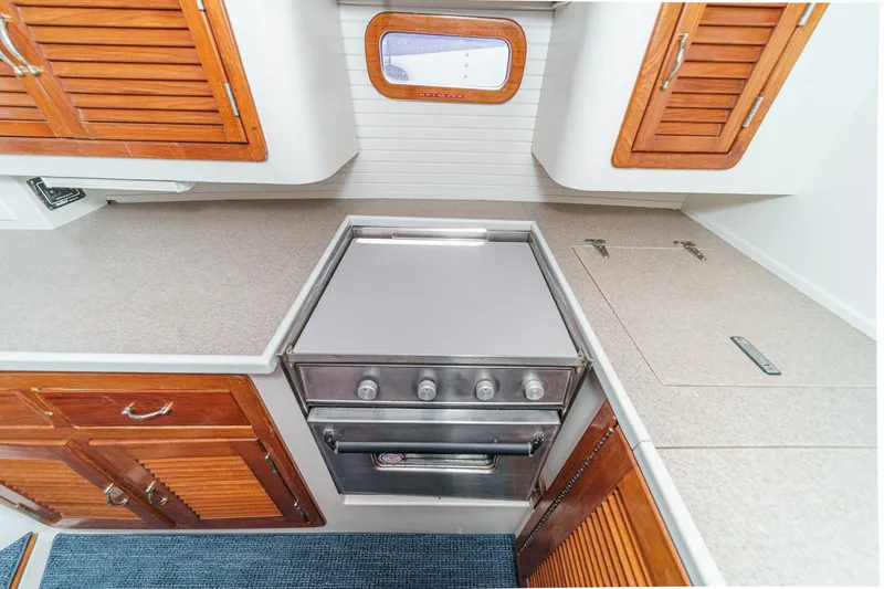 Slide: The Image of 1992 Morgan 45 Catalina yacht kitchen with stove, wooden cabinets, and countertop. - 38