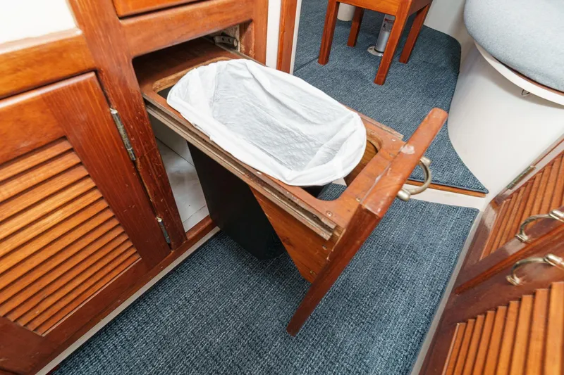 Slide: The Image of Pull-out trash bin in 1992 Morgan 45 Catalina yacht interior with wooden cabinetry. - 42
