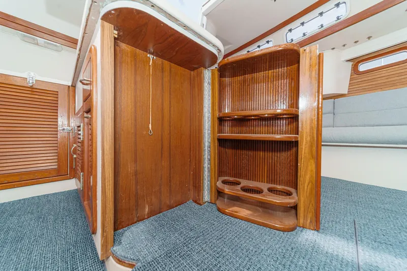 Slide: The Image of Interior of 1992 Morgan 45 Catalina sailboat with wooden cabinetry and shelving. - 43