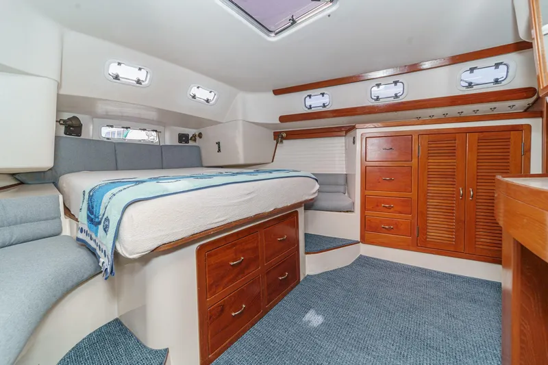 Slide: The Image of 1992 Morgan 45 Catalina yacht cabin with bed, wooden cabinets, and portholes. - 49