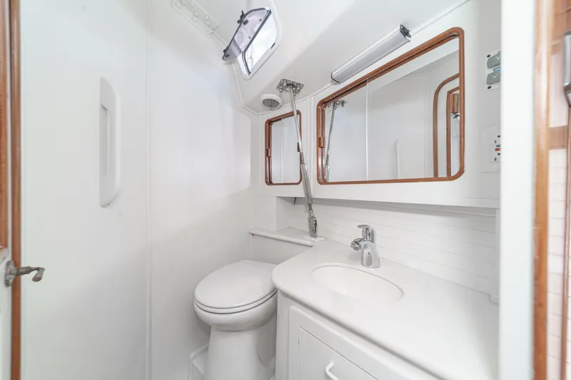 Slide: The Image of 1992 Morgan 45 Catalina yacht bathroom with white fixtures and wooden accents. - 58