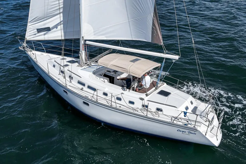 Slide: The Image of 1992 Morgan 45 Catalina sailboat cruising on open water with white sails. - 8