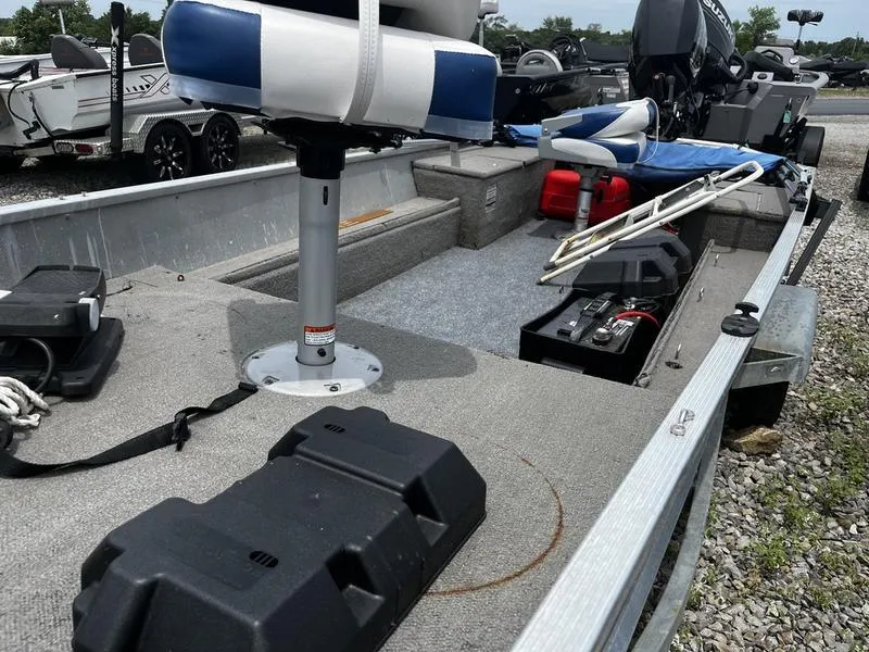 Slide: The Image of 1996 Tracker Pro 15 boat interior with seating, storage, and equipment on a gravel surface. - 2