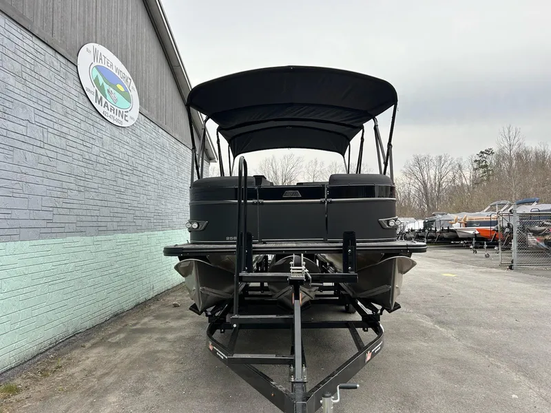 Slide: The Image of 2025 Avalon 2585 Catalina Entertainer pontoon boat on trailer, parked outside a marine shop. - 3
