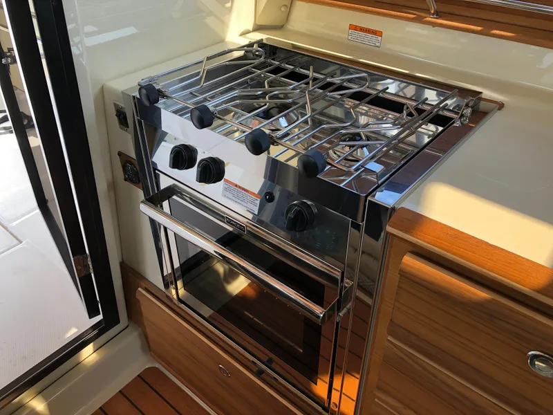 Slide: The Image of Stainless steel stove and oven in 2022 Ranger Tugs R-27 boat kitchen. - 11