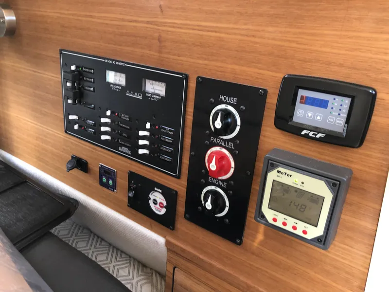 Slide: The Image of Control panel of 2022 Ranger Tugs R-27 boat with various switches and displays. - 12