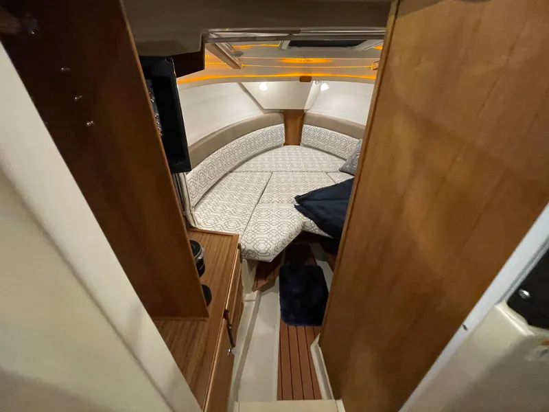 Slide: The Image of 2022 Ranger Tugs R-27 cabin interior with cozy seating and wood accents. - 13