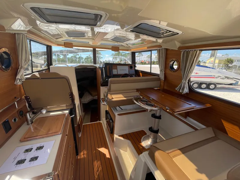 Slide: The Image of Interior of 2022 Ranger Tugs R-27 boat, featuring wood accents and modern amenities. - 4