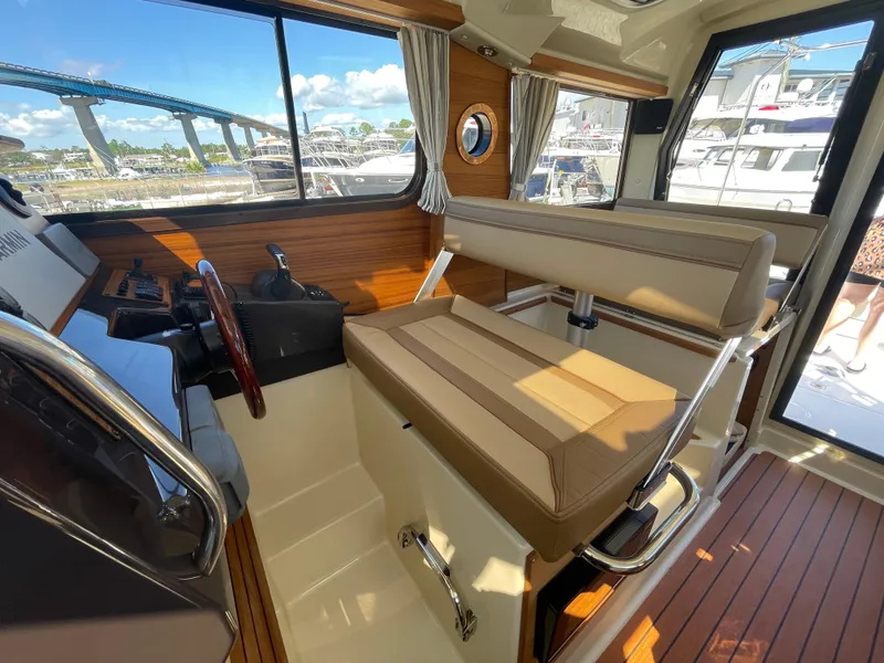Slide: The Image of Interior of 2022 Ranger Tugs R-27 boat with helm and seating area. - 5