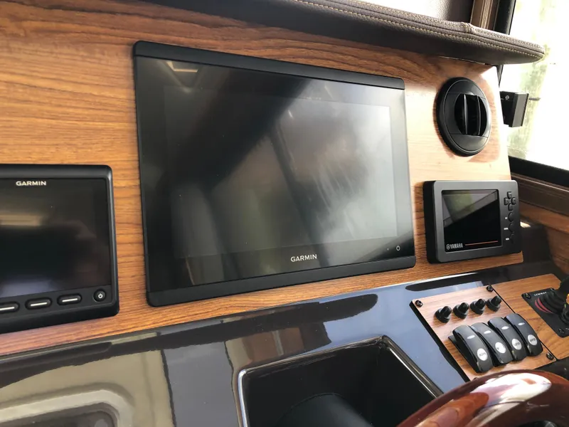 Slide: The Image of Dashboard of 2022 Ranger Tugs R-27 with Garmin navigation displays and controls. - 7