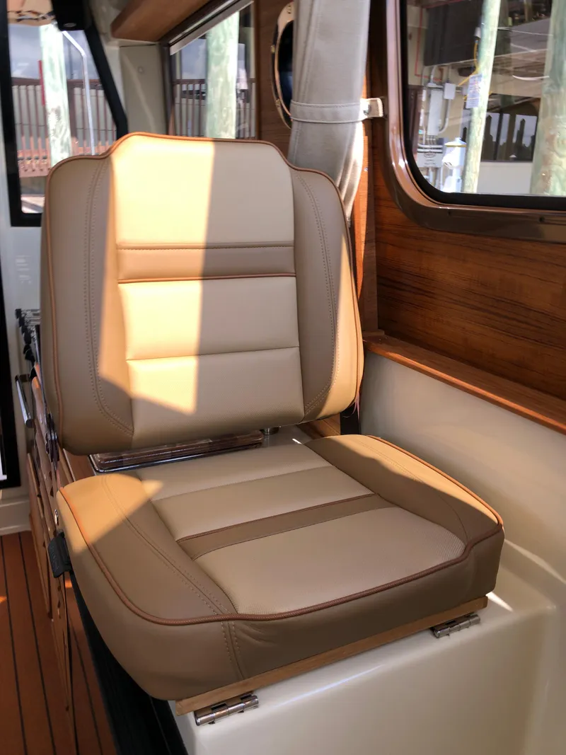 Slide: The Image of 2022 Ranger Tugs R-27 interior with tan leather seat and wooden accents. - 9